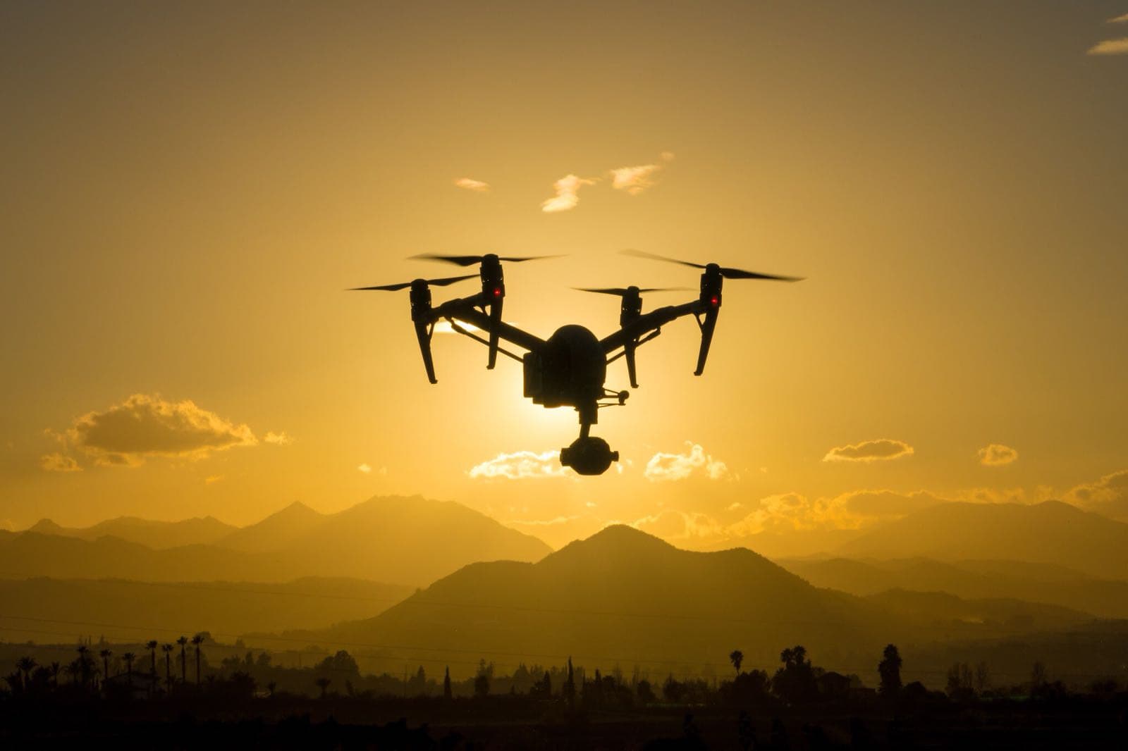 dji inspire 2 drone in flight with gradient orange background at sunset