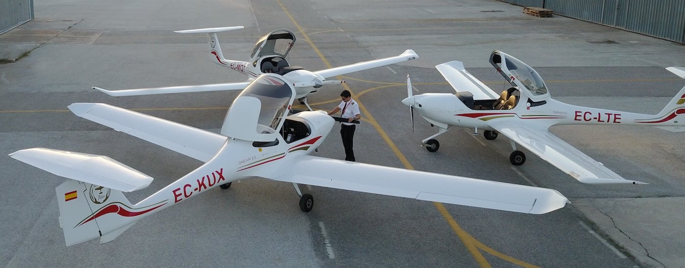 one pilot air inspecting Diamond DA20 aircraft propeller with two other aircraft next