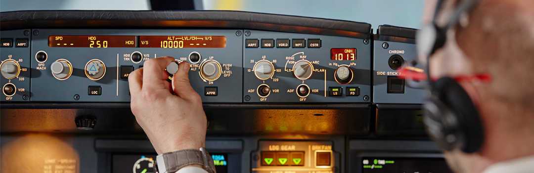 a pilot adjusting controls in a plane dashboard