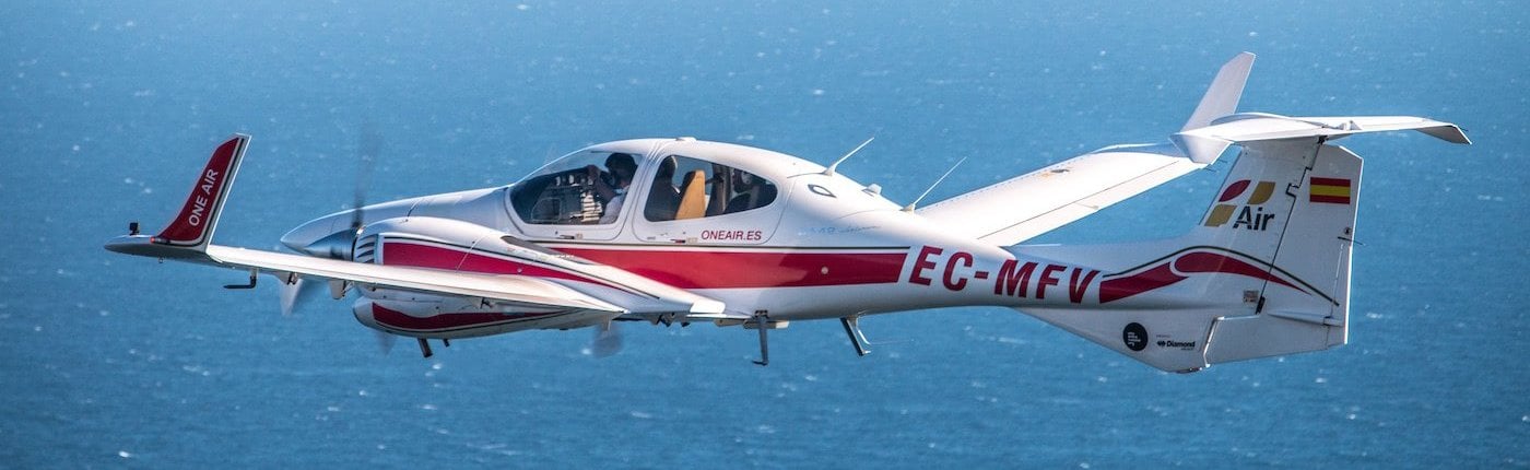 a diamond da42 aircraft in flight above the sea