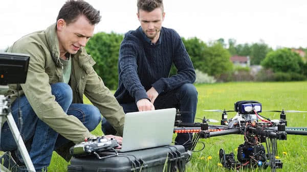 surveyors preparing industrial drone to mapping a land